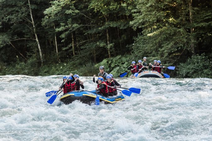 Zwei Raftingboote fahren durch das Wildwasser der Saalach bei Lofer